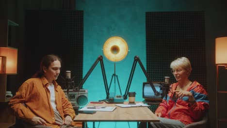 cheerful podcast co-hosts introducing themselves on camera in recording studio