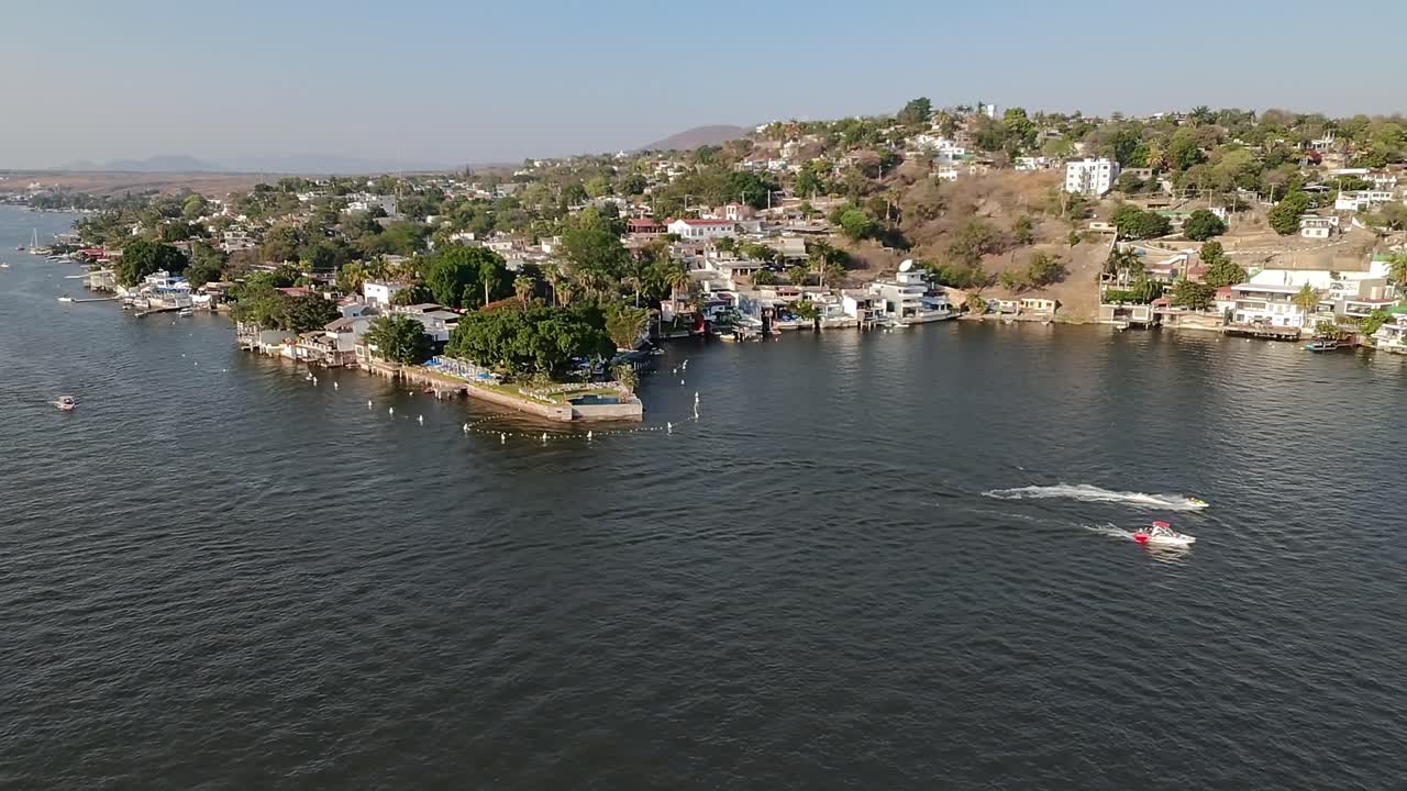 Laguna tequesquitengo showcasing its scenic waterfront with boats passing by, aerial view