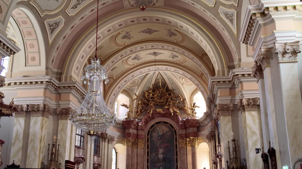 Interior tilt down view of Saint George’s Catholic Cathedral in Timisoara, Romania, revealing intricate ceiling details and the ornate altar below