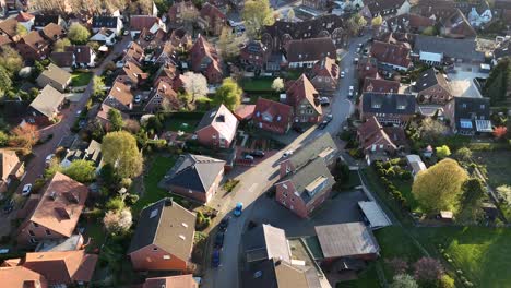 Cars on street of historic american town during sunset time. Aerial top down flyover shot. Tracking shot. Red orange tiles on roof with colored trees in springtime.
