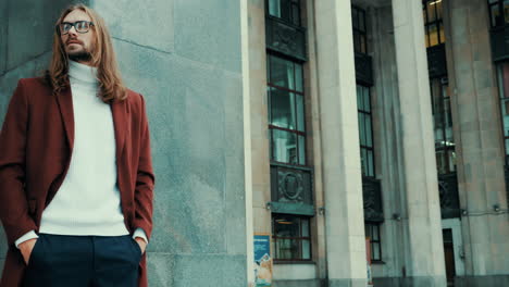 atractivo hombre hipster barbudo en abrigo de moda rojo