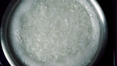 arroz blanco de punto de ebullición con vapor en un recipiente de acero, cerrado
