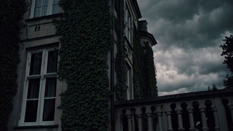 ivy-covered old house under a stormy sky