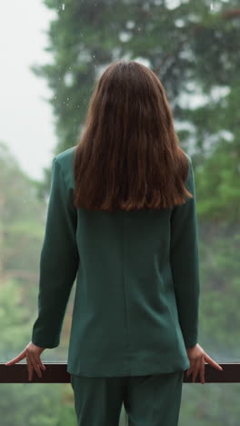 sad corporate employee looks at rain behind window. lady top manager thinks about lost chances for company growth in office. woman with depression disorder