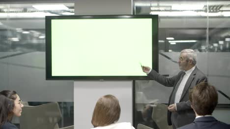 orador confiado hablando con sus colegas y apuntando a la pantalla