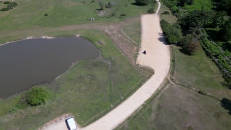 El-Viaje-De-Un-Ciclista-Junto-Al-Lago-En-Un-Bosque-Nuevo-Capturado-Desde-Arriba