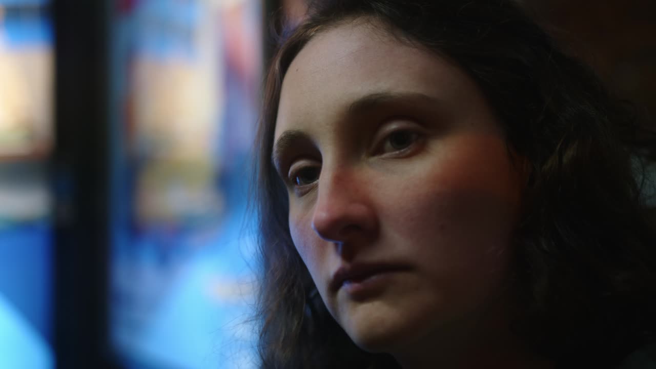 un primer plano de una mujer caucásica con una cara seria y triste.