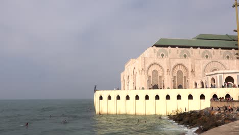 view of beautiful towering minaret of hassan ii mosque from the bank of atlantic ocean in casablanca, morocco