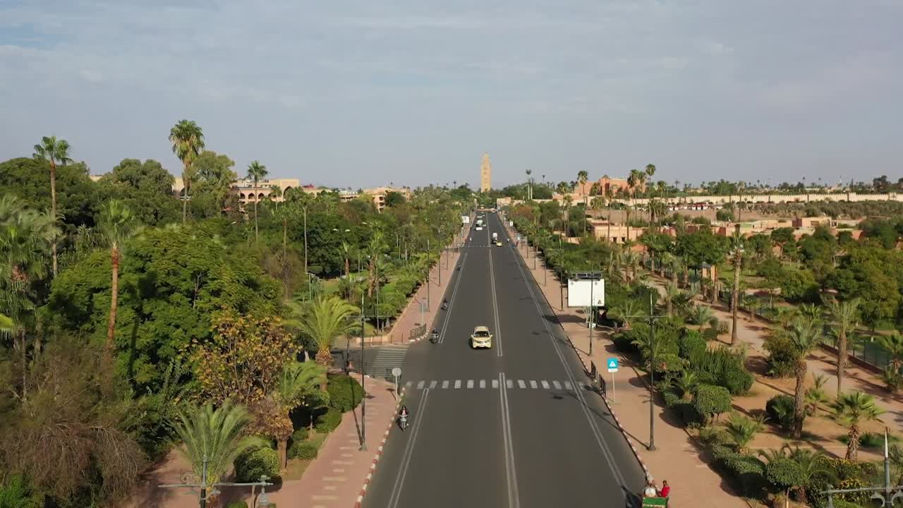 Ripresa panoramica con drone che mostra un complesso svincolo autostradale con paesaggi verdi. Evidenzia l'avanzata infrastruttura stradale e lo sviluppo urbano in un moderno quartiere marocchino.