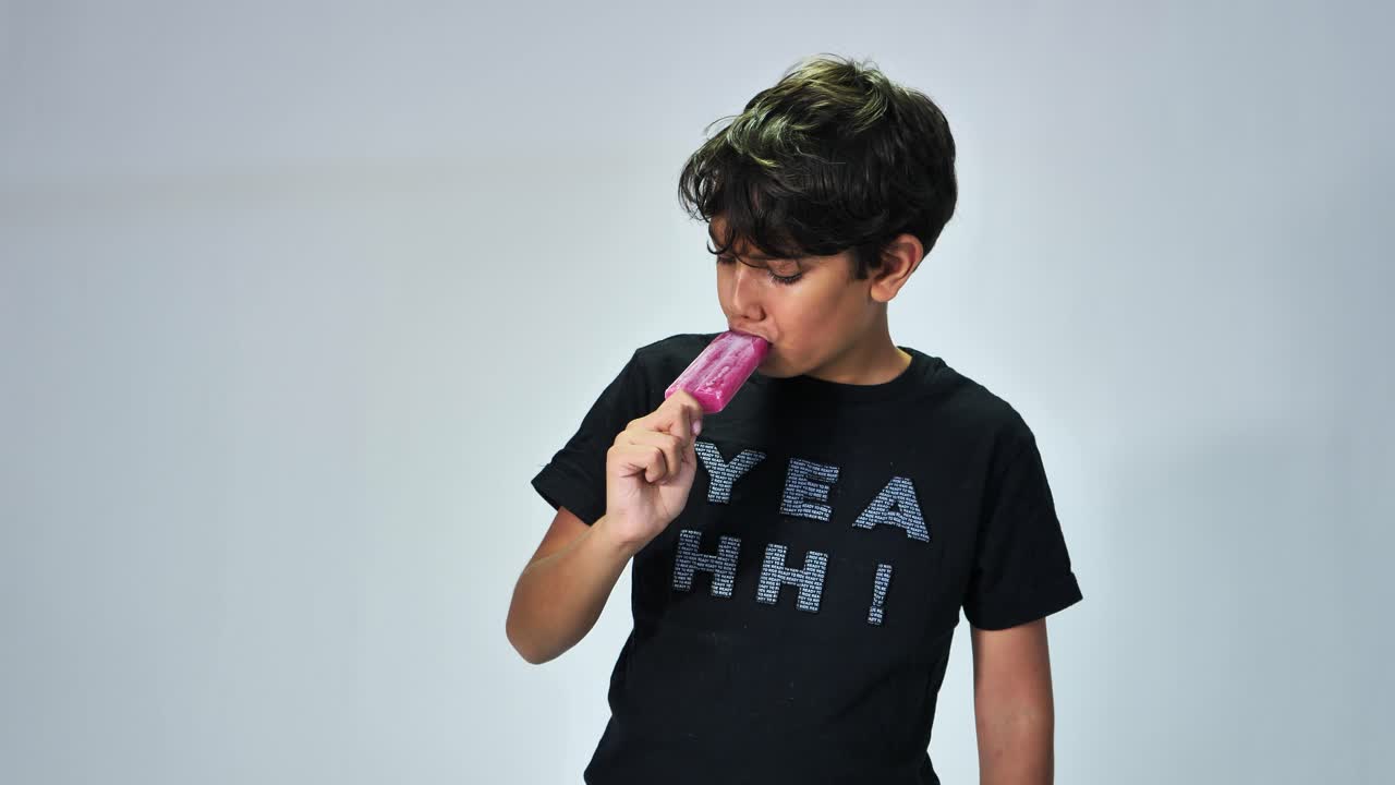 niño del medio oriente comiendo helado con un fondo blanco