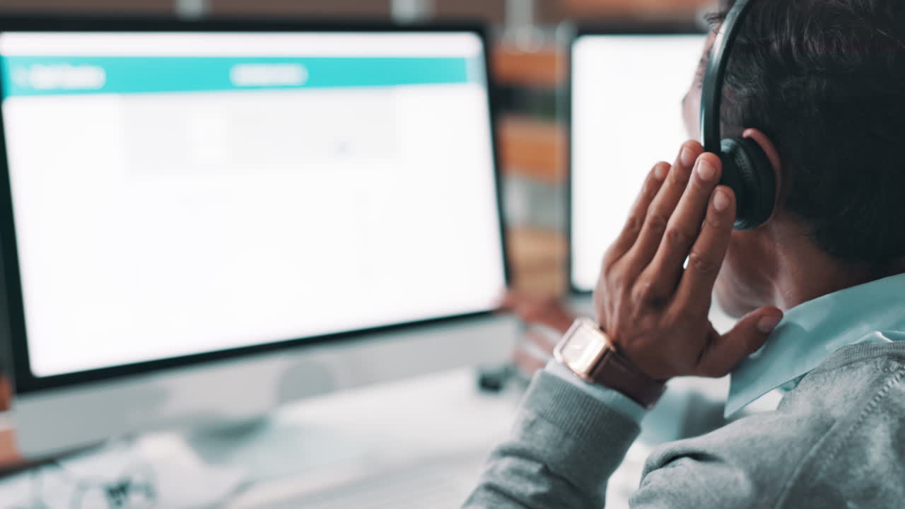 Man working on computer with headphones