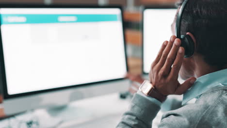 man working on computer with headphones