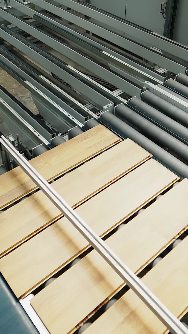 Industrial equipment for the production of laminate. Several stages of floor production. Vertical video