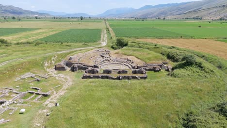 drone shot of the ruins of the antique hadrianoplis theatre and ancient city in the middle of green fields