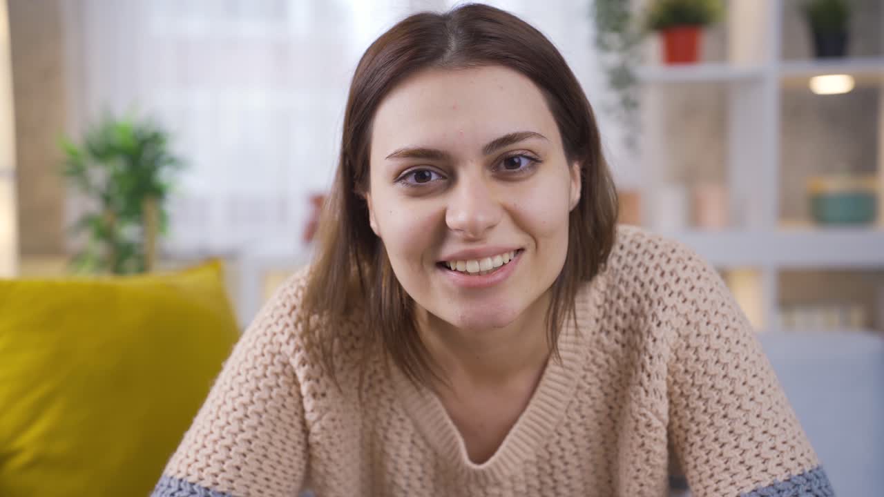 Affascinante giovane ragazza che guarda la telecamera, strizzando l'occhio e sorridendo.