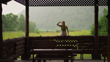 lady holds hand over eyes and looks at distant mountains