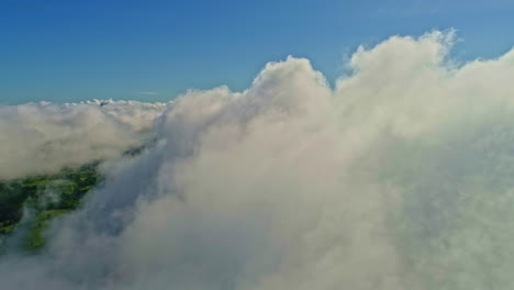 closeup flight through fluffy clouds covering rural landscape