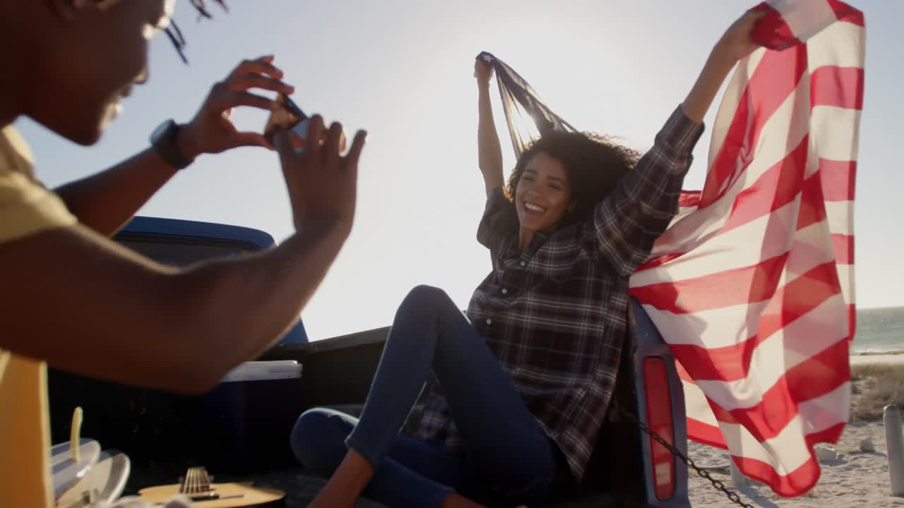 hombre tomando fotos de mujer con teléfono móvil en la playa 4k