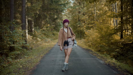 female explorer twirling leg on road by forest