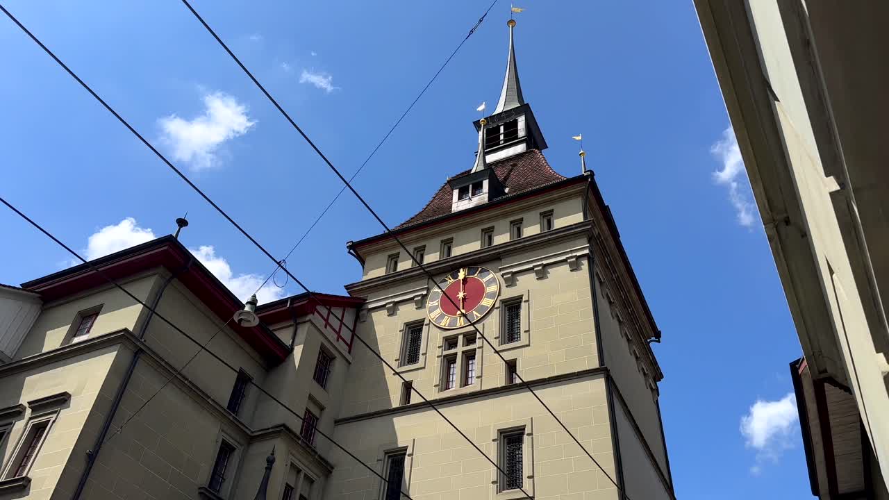 Tilt down of historic clock tower in Bern City. Prison Tower of old town during sunny day. Capital of Switzerland.