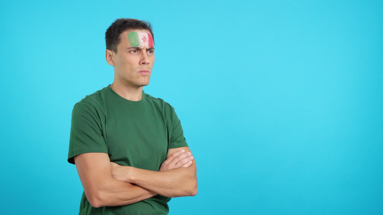 Man with mexican flag painted looking away with serious expression