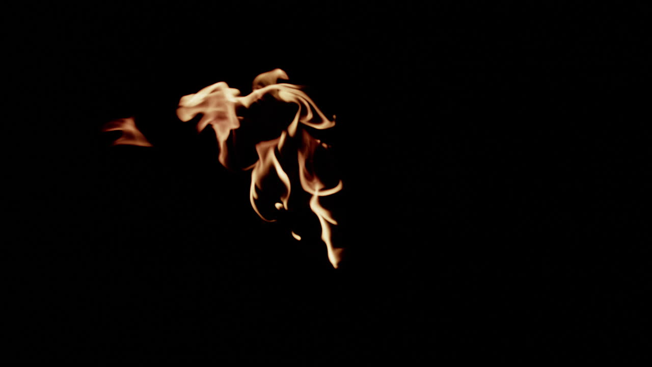 Slow motion flames in center of screen that blow to the left as they burn.