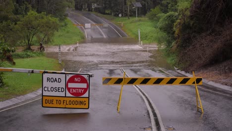 Gold Coast, Queensland, 16 February 2024 - Signage indicating road closure due to flooding across Hardy's Road in Mudgeeraba after heavy rains continue to lash South East Queensland, Australia