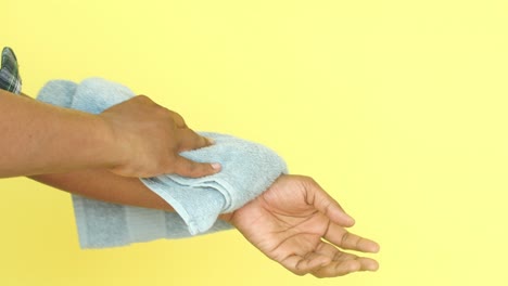 man wiping sweat from his arm with a towel.