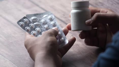 person holding pills and medication bottle