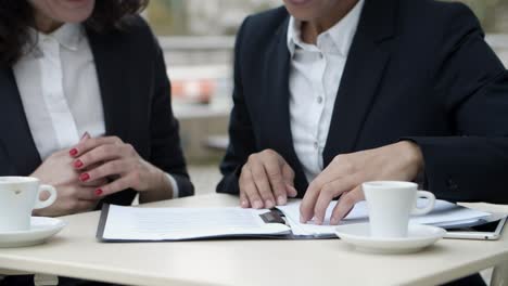 businesswomen discussign contract in cafe