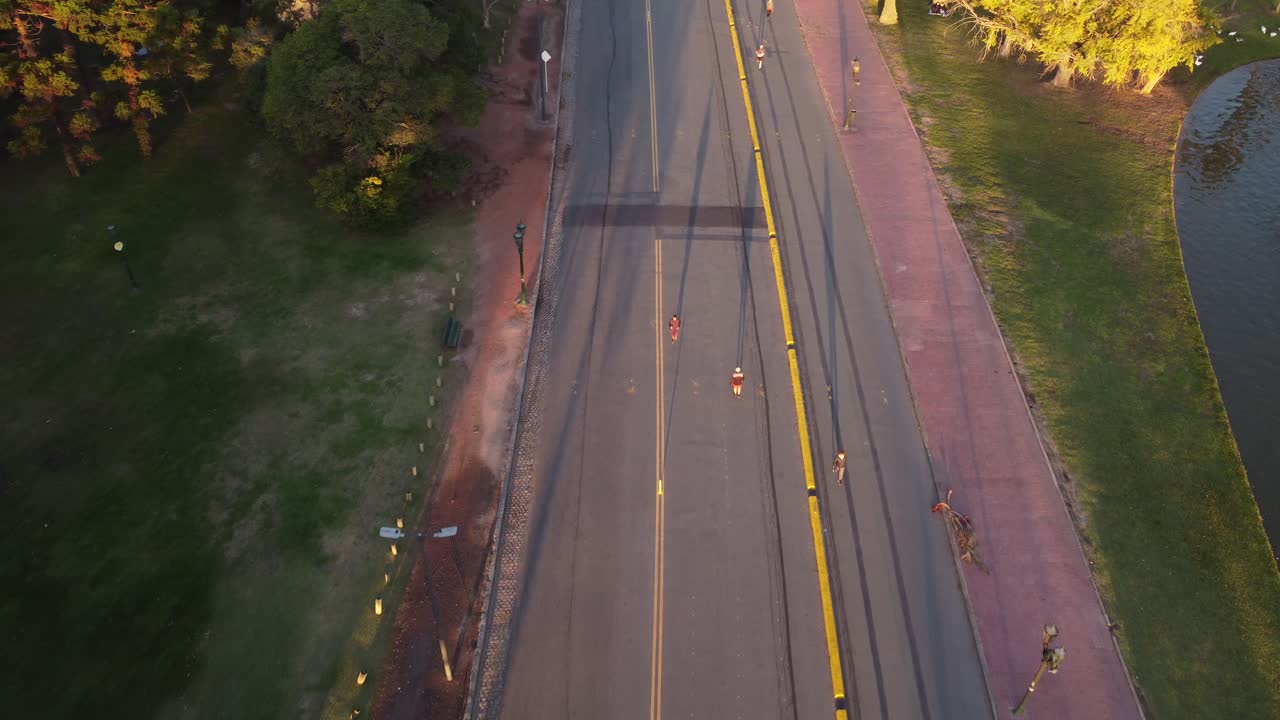 일몰 동안 부에노스 아이레스의 팔레르모 공원에서 길을 걷고 있는 남성 주자의 공중 샷