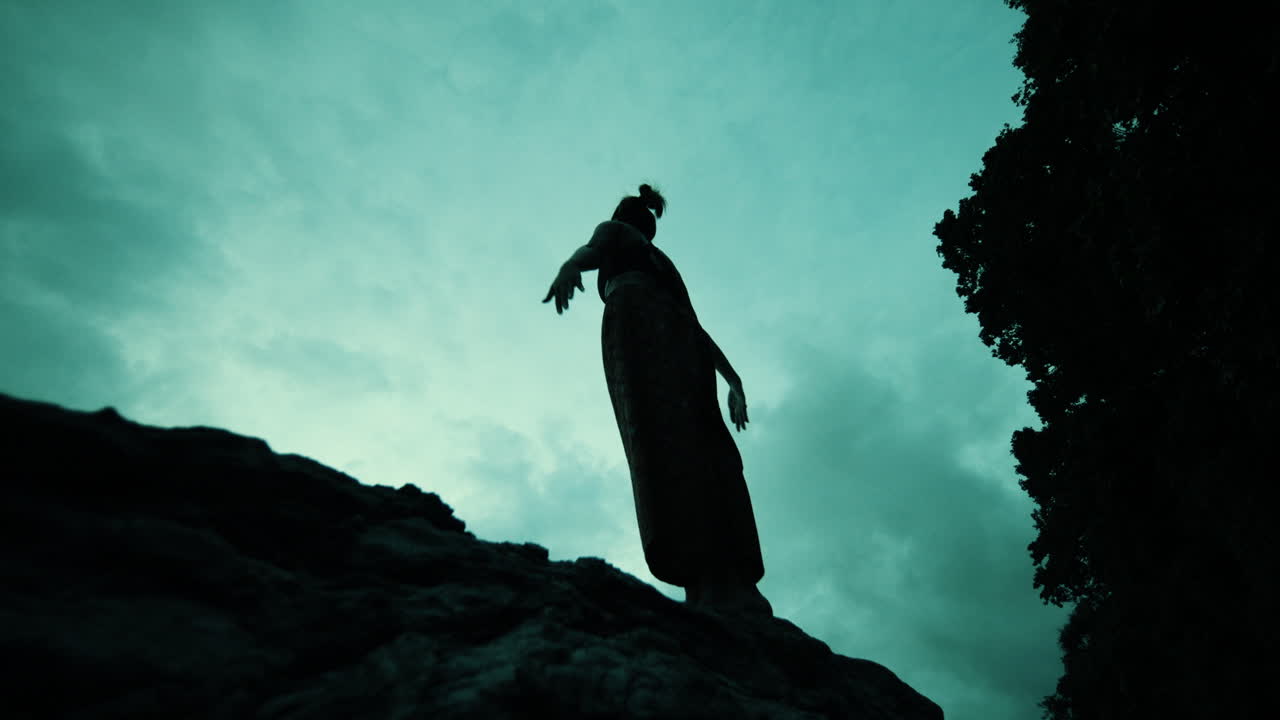 Woman Silhouetted Against Dramatic Sky