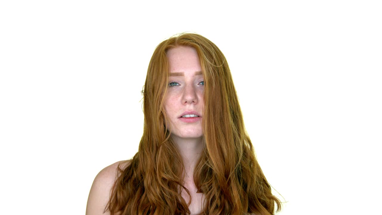 hermosa mujer pelirroja sensual con el pelo largo y ondulado rojo mirando a la cámara