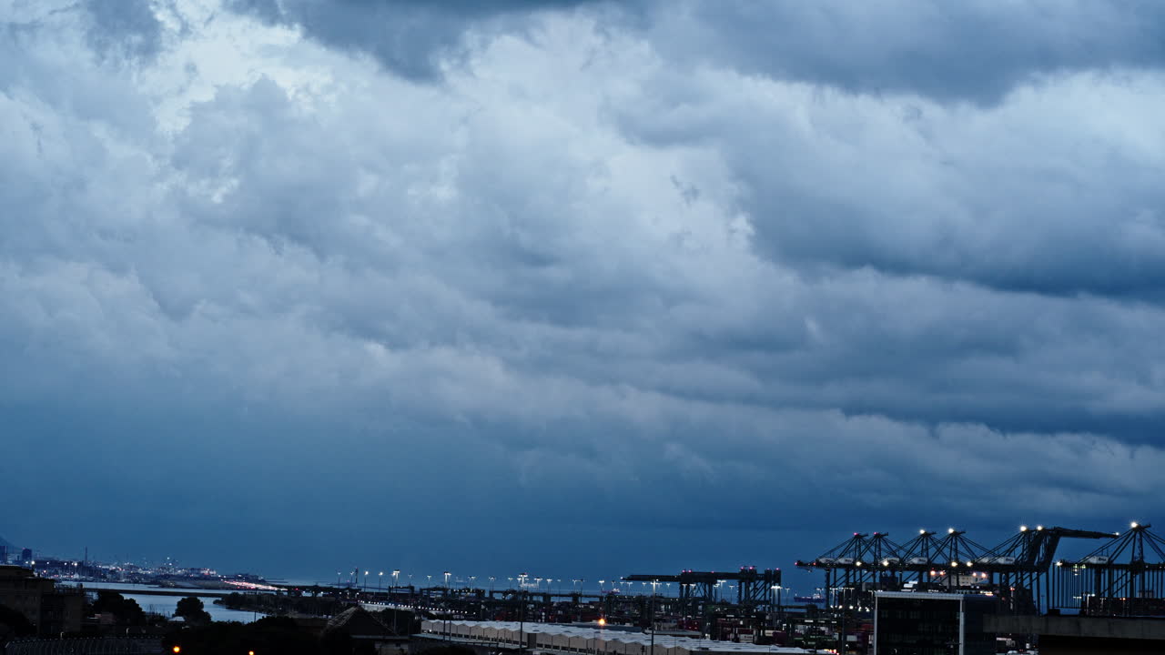 Dramatic clouds over port cranes in a swift time-lapse