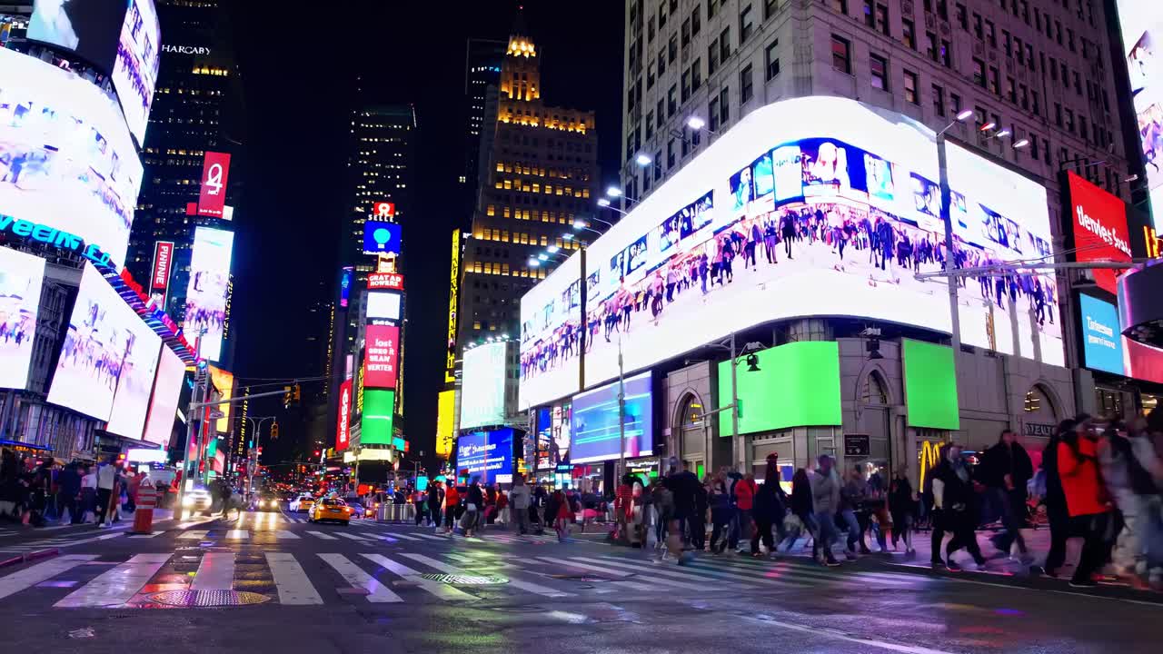 Street-level view of a bustling cityscape at night, showcasing vibrant digital billboards