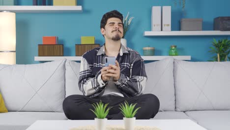 un joven feliz enviando mensajes de texto por teléfono.