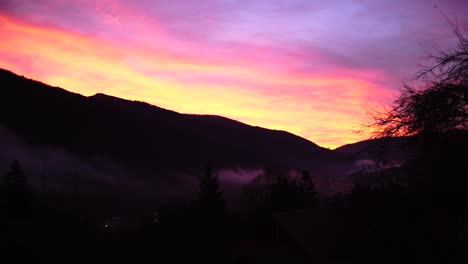 Static-Timelapse-Of-Sunrise-Over-Mountain-Ridge-With-Fog-In-The-Valley