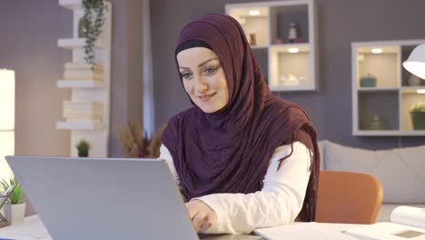 Mujer-Con-Hijab-Mirando-Una-Computadora-Portátil-Y-Sonriendo.