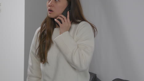 anxious or stressed woman taking call on mobile phone at work in office building 2