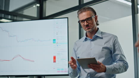 charismatic businessman showing tv screen close up. mentor presenting product