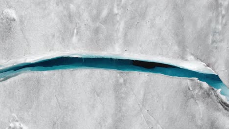 Aerial:-top-down-shot-of-crevasse-in-glacier-ice-sheet,-natural-formation