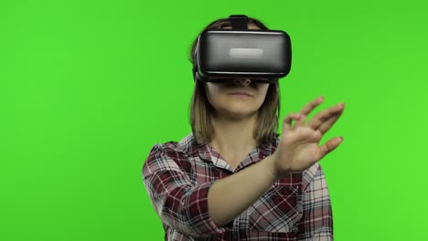 woman using vr headset helmet to play game. watching virtual reality 3d 360 video. presses buttons