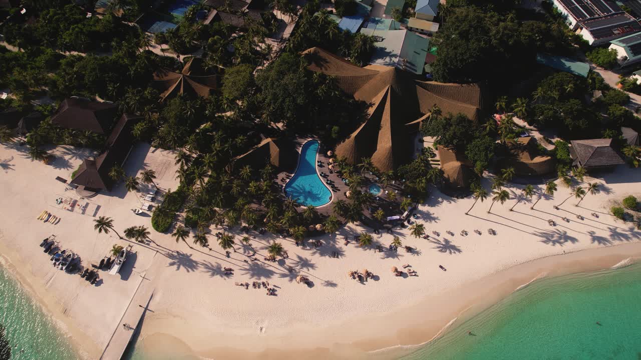 toma real de la hermosa playa de arena dorada de kuredu island resort en maldivas con palmeras y una gran piscina