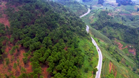 revealing shot of vehicles traveling on a dangerous mountain road