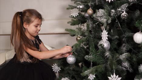 niña decorando el árbol de navidad