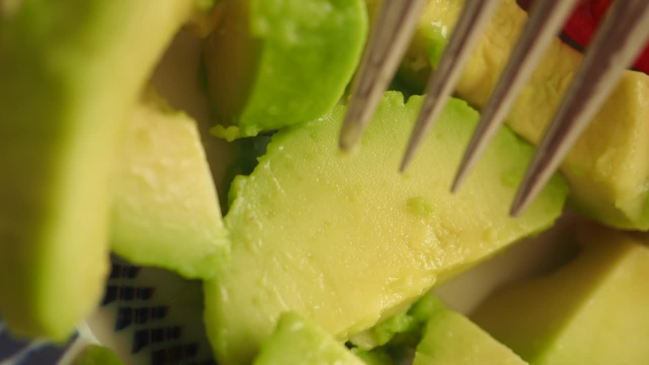 Avocado being prepared with fork