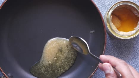 pouring ghee into a pan