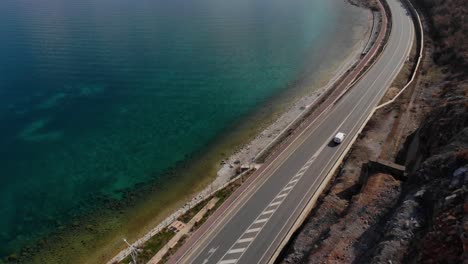 road alongside beautiful lake shore with calm crystal water, travel concept