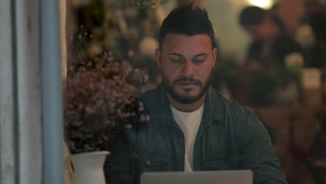 concentrated man using laptop in coffee shop