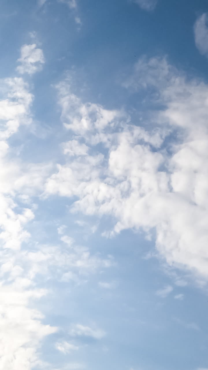 Slow transformation of spindrift clouds in the atmosphere. White clouds covering the skies low angle view. Timelapse. Vertical video